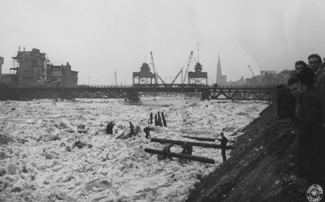 Ein Fluss voller Eistrümmer, im Hintergrund eine Brücke, Schwarz-Weiß-Fotografie; Quelle: Staatsarchiv Bremen